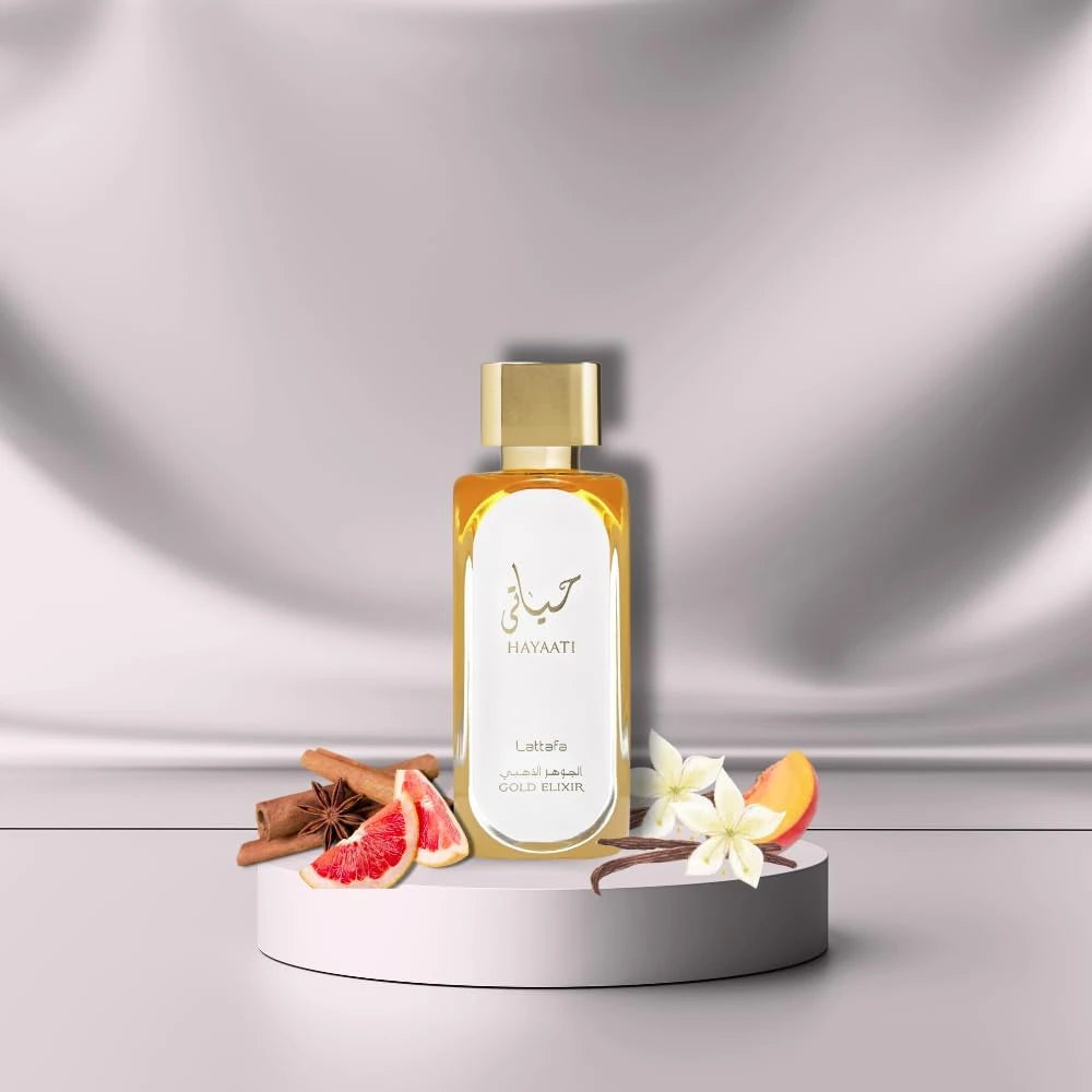 Hayaati Gold Elixir fragrance – bottle flat-lay with spices and citrus on satin