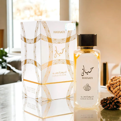 Hayaati Gold Elixir fragrance – box and bottle on marble with greenery
